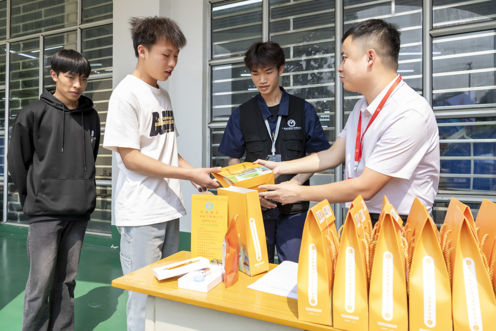 老师为学生颁发礼品（覃淑惠摄）